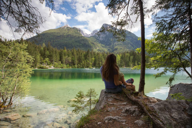 istock MOther and daughter sitting on a lake 958981108