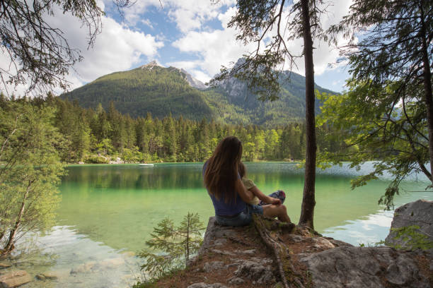 istock MOther and daughter sitting on a lake 958981296