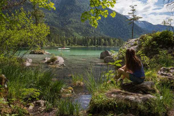 istock MOther and daughter sitting on a lake 958981432