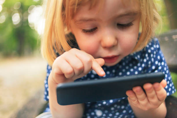 Little child using smart phone stock photo