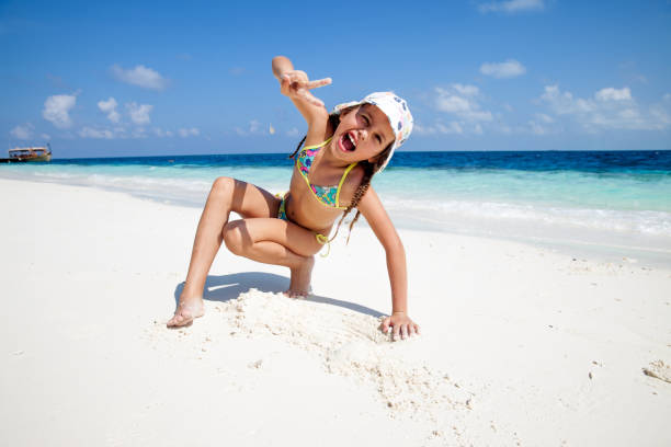 istock Happy Playful Girl Having Fun on Sandy Beach 958987646