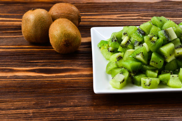 istock Freshly sliced kiwi fruit with whole kiwis in background. 958987808