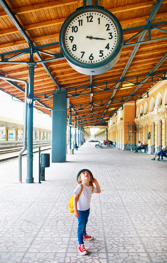 Cute little boy at the train station. Looking train station clock.