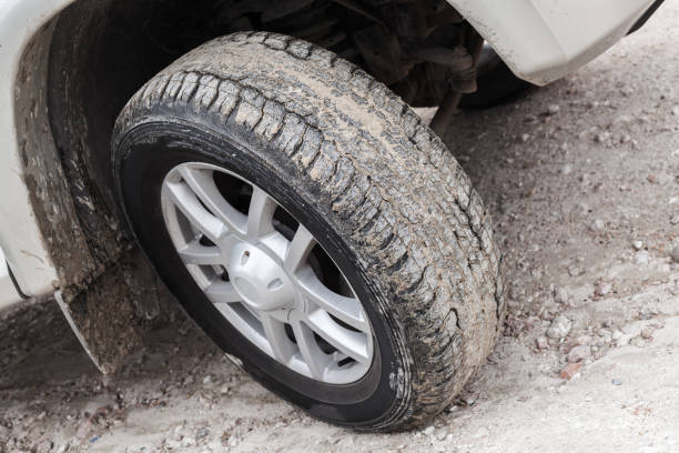 istock Car wheel on dirty country ground 958992340