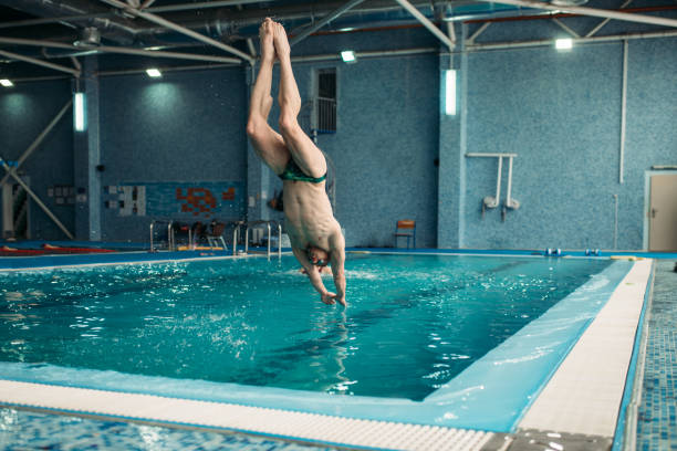 istock Swimmer in goggles jumping from the tower 958993058