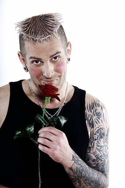 istock romantic man with tatoo smelling a rose flower 95899414