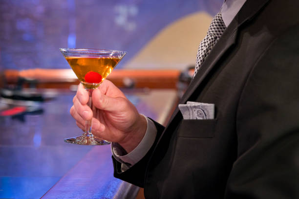 istock Man at bar holding a martini, business suit 958996662