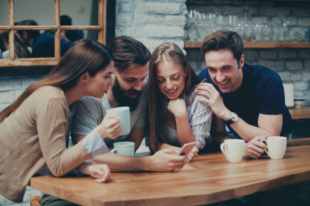istock Four people looking at the phone 959008168