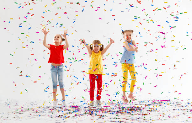 istock happy children on holidays  jumping in multicolored confetti on white 959011442