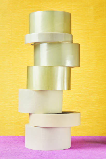 istock Tower of tape self adhesive bopp on yellow background. 959013466