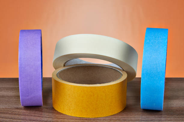 istock Several multi-colored rolls of adhesive tape on an orange background. 959014868