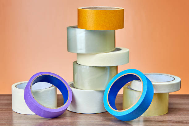 istock Different rolls of duct tape lie on table, orange background. 959014922