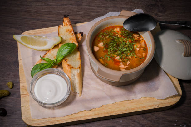 istock Soup on a wooden background with white bread and sauce 959015800