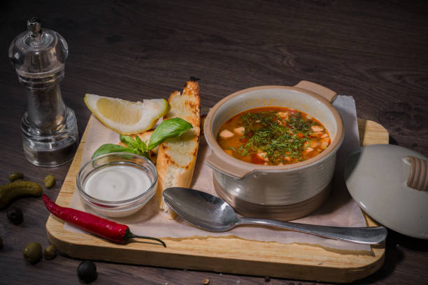 istock Soup on a wooden background with white bread and sauce 959015814