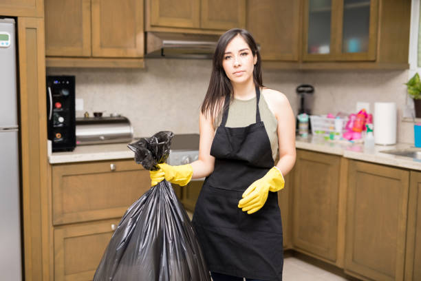 istock Young maid holding garbage bag in kitchen 959020216