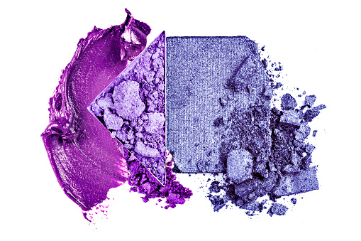 Purple crushed eyeshadow and smeared lipstick on a white background.