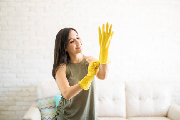 istock Delighted woman putting on yellow gloves 959020428