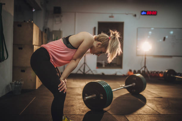 Woman is tired of training One woman in gym, girl tired of weights training. blonde female bodybuilders stock pictures, royalty-free photos & images