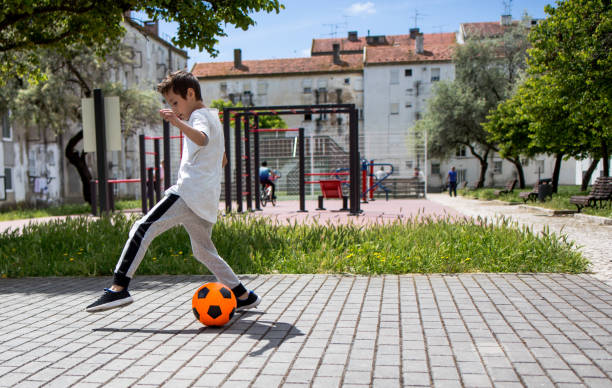 istock Boy play with football ball 959023122