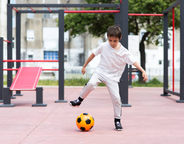 istock Boy play with football ball 959023210