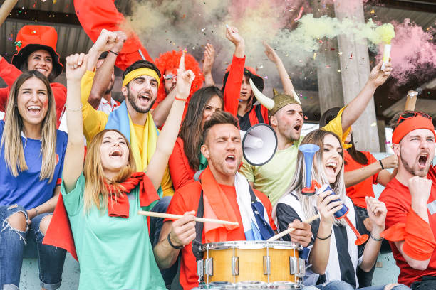 Football supporter fans watching international soccer match - Young group of excited friends having fun exulting at soccer world game at stadium - Youth, sport and celebration score concept aficionados al fútbol partidario viendo partido de fútbol internacional - grupo joven de amigos muy contentos de tener diversión gloriando en el juego mundial de futbol en el estadio - juventud, deporte y anotar el concepto de celebración