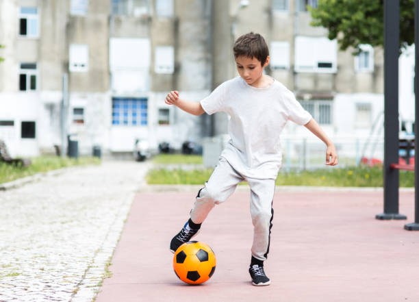 istock Boy play with football ball 959023248