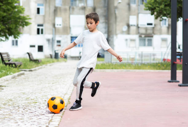 istock Boy play with football ball 959023262