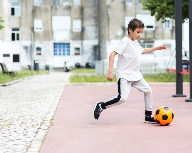 istock Boy play with football ball 959023264
