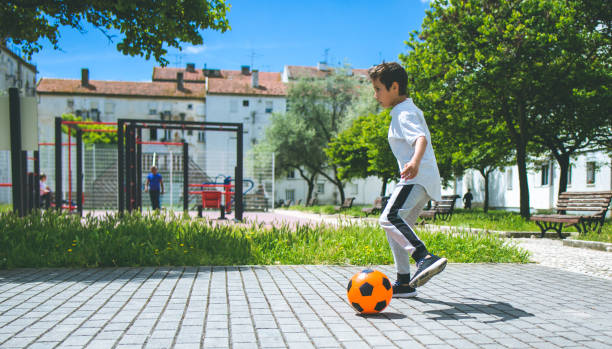 istock Boy play with football ball 959023476