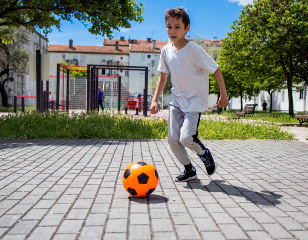 istock Boy play with football ball 959023486