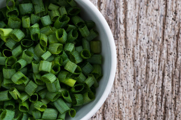 istock Chopped spring onions in white bowl 959024098