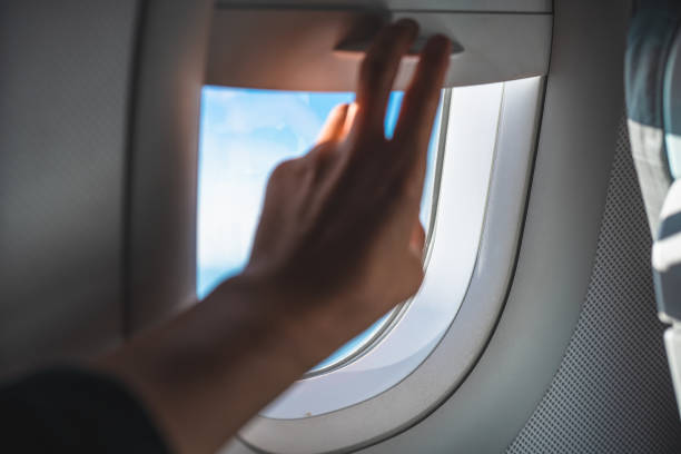 istock Man Adjusting the Blinds on an Airplane Window POV 959027124