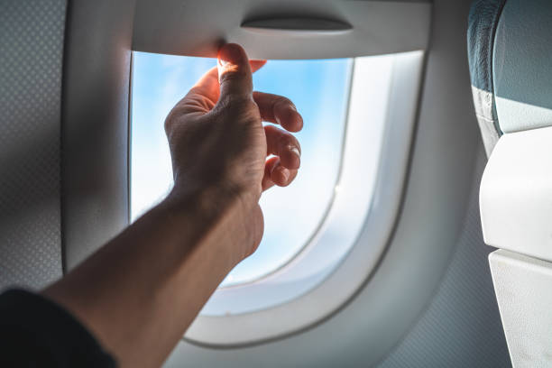 istock Man Adjusting the Blinds on an Airplane Window POV 959027168