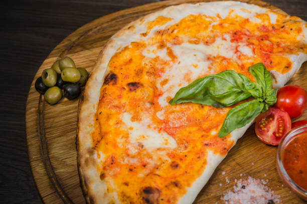 istock Hot piece of pizza with melted cheese on a rustic wooden table 959027174