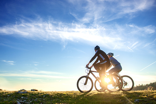 Par de bicicletas de montaña feliz al aire libre divertirse juntos en un puesta de sol por la tarde de verano photo