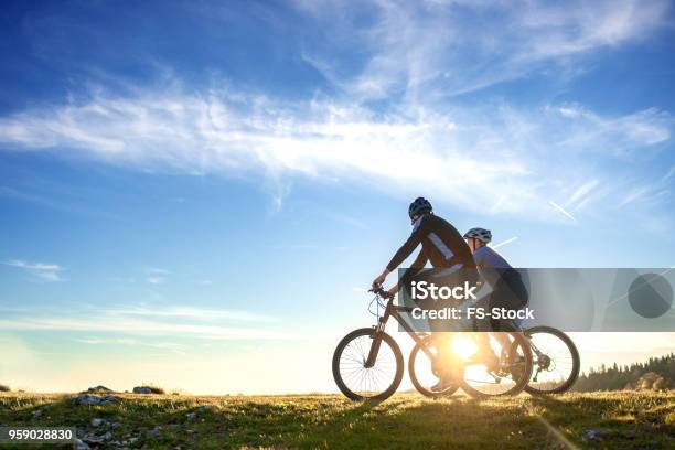 Happy Mountain Bike Couple Outdoors Have Fun Together On A Summer Afternoon Sunset Stock Photo - Download Image Now