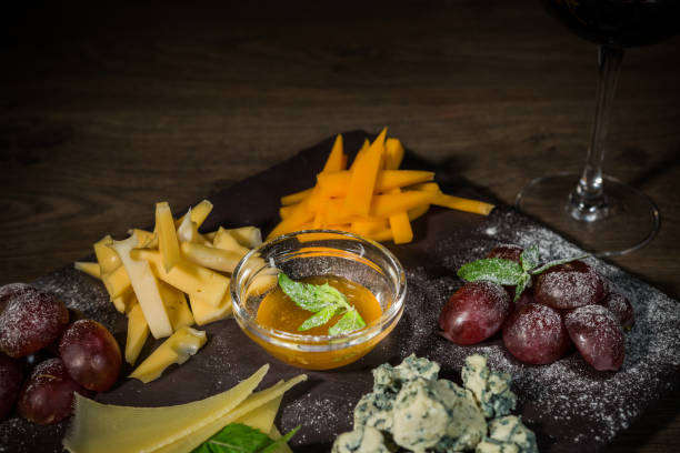 istock Cheese mix with honey and grapes on a stone background 959031384