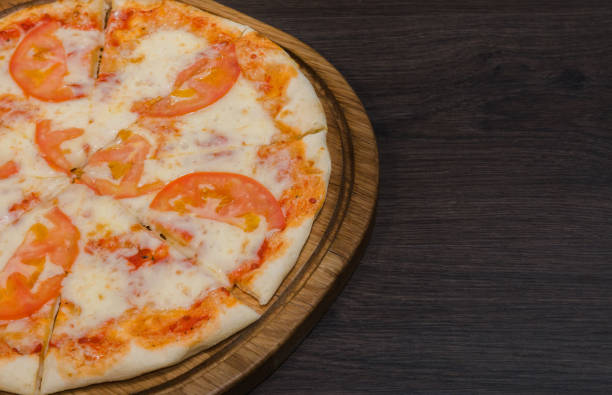 istock Hot piece of pizza with melted cheese on a rustic wooden table 959035298