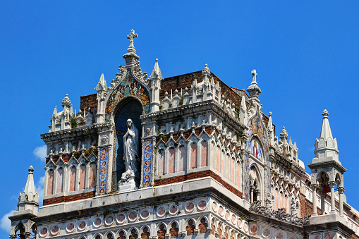 Close-up of Gothic Revival style Capuchin Church of Our Lady of Lourdes with carvings, reliefs and statue of Mary against the blue sky in a sunny summer day, downtown Rijeka port city Croatia Europe