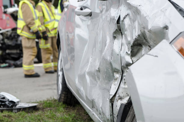 istock Close up on a car crashed with policeman and fireman in background 959038502