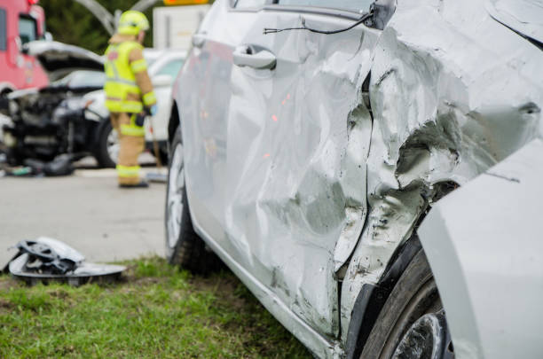 istock Close up on a car crashed with fireman in background 959038842
