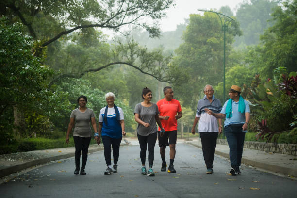 grupo de adultos mayores activas disfrutando de sus años dorados - walking exercising relaxation exercise group of people fotografías e imágenes de stock