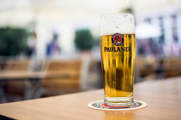 um copo de paulaner legal alemão cerveja em uma mesa de madeira - paulaner - fotografias e filmes do acervo