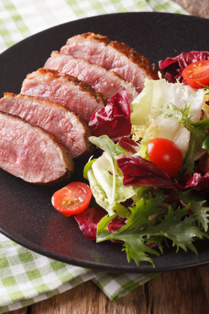 istock Roast duck breast with fresh mixed salad close-up. vertical 959065620