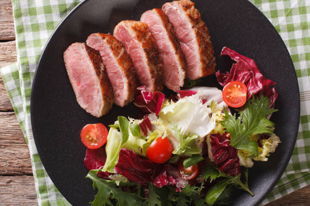 istock roast duck breast and fresh mix lettuce close-up. horizontal top view 959066386