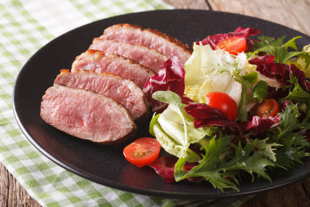 istock roast duck breast and fresh mix lettuce close-up. Horizontal 959066412
