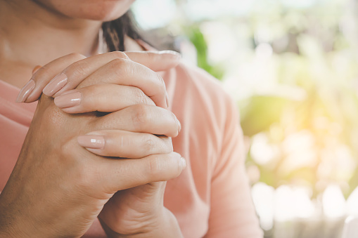 woman hand praying peacefully outdoors in the morning