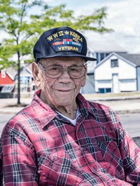 Smiling WWII and Korean War USA Military Veteran Senior adult 95 year old man World War II and Korean War USA military veteran sitting near the lake looking at the camera with a smiling facial expression. He is wearing an inexpensive, non-branded, generic, souvenir shop replica military veteran commemorative baseball style cap.
NOTE: There are no official or authentic military uniform elements of any kind in this image - and no intent to portray anything other than a proud and patriotic, authentic United States military war veteran. tartan army stock pictures, royalty-free photos & images