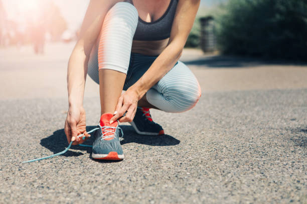 istock Fit young woman typing laces on sneakers 959070974