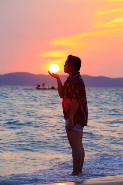 istock man happy with the sunset on the beach 959071012